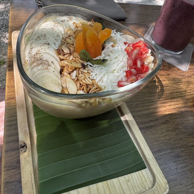 Un smoothie bowl con el jardín de ARCANA al fondo