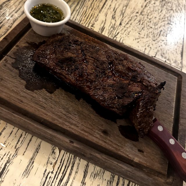Corte argentino con chimichurri en tabla en Fuego Santo