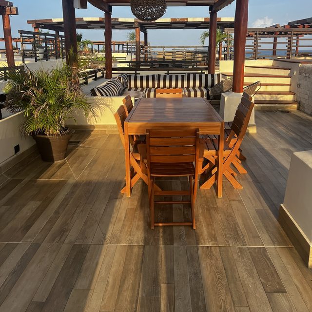 La azotea al atardecer: comedor bajo la pérgola y salas para todo el grupo