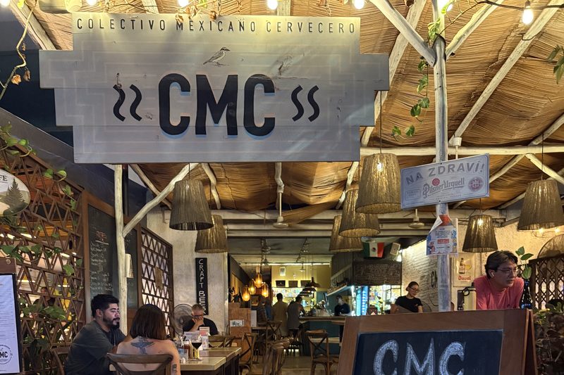 El letrero de Colectivo Mexicano Cervecero sobre el comedor abierto de CMC, bajo un techo de palapa